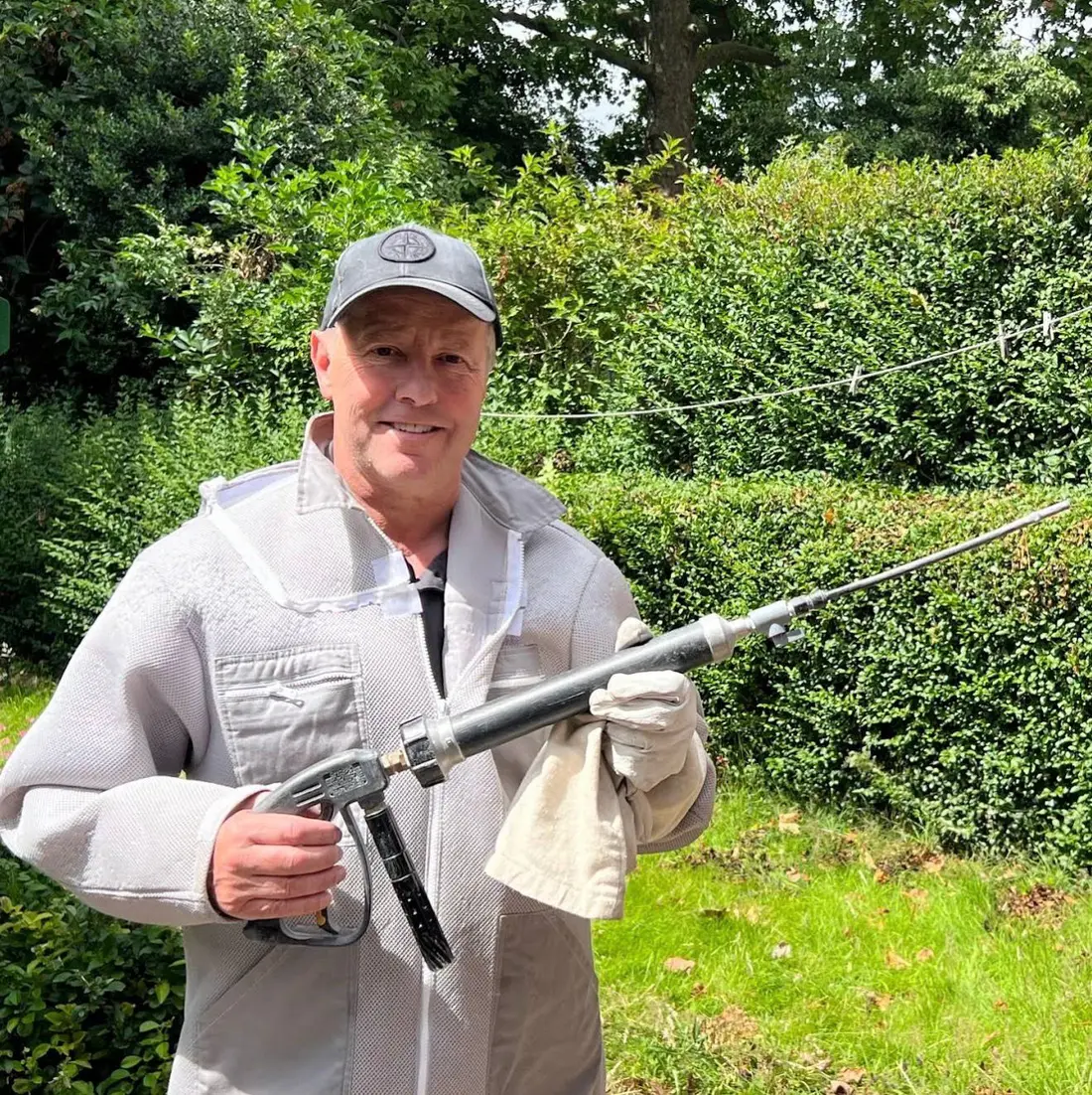 Yor-Pest Control technician in protective equipment holding professional extension lance for wasp nest removal York Harrogate